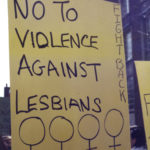 Placard at International Women's Day in Toronto calls for fighting back against violence against lesbians.