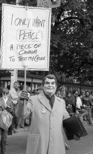 The October 22, 1983 “Refuse the Cruise” protest in Toronto was co-sponsored by the Toronto Disarmament Network (TDN) and the Against Cruise Testing Coalition (ACT). The International Women’s Day Committee was one of many groups to support the march. Sheryl Pollock, a member of IWDC, can be seen to the left and behind “Reagan”.