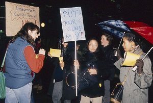 In response to the October 27, 1989, police shooting of 23-year-old Black woman Sophia Cook, the Black Women’s Collective organized the Women’s Coalition Against Racism and Police Violence. This coalition of 35 women’s and progressive organizations brought people together on December 16, 1989, to demand police accountability and an end to police brutality against Black people. This photo shows banners demanding that police put their guns away and calls for an Independent Civilian Review.