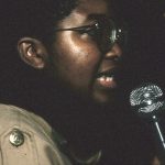 Angela Robertson, member of the Black Women's Collective, speaks at a protest against police violence. In response to the October 27, 1989, police shooting of 23-year-old Black woman Sophia Cook, the Black Women’s Collective organized the Women’s Coalition Against Racism and Police Violence. This coalition of 35 women’s and progressive organizations brought people together on December 16, 1989, to demand police accountability and an end to police brutality against Black people.