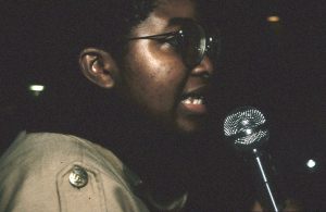 Angela Robertson, member of the Black Women's Collective, speaks at a protest against police violence. In response to the October 27, 1989, police shooting of 23-year-old Black woman Sophia Cook, the Black Women’s Collective organized the Women’s Coalition Against Racism and Police Violence. This coalition of 35 women’s and progressive organizations brought people together on December 16, 1989, to demand police accountability and an end to police brutality against Black people.