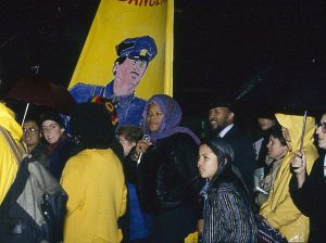 Leleti Tamu, member of the Black Women's Collective, is surrounded by others at the Sophia Cook protest. In response to the October 27, 1989 police shooting of 23-year-old Black woman Sophia Cook, the Black Women’s Collective organized the Women’s Coalition Against Racism and Police Violence. This coalition of 35 women’s and progressive organizations brought people together on December 16, 1989, to demand police accountability and an end to police brutality against Black people.