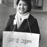 Shirley Lowe, a staff member of the Languages Department, holdes picket sign. Staff in this department provided services in over 40 languages, and many brought their own signs to the picket line.