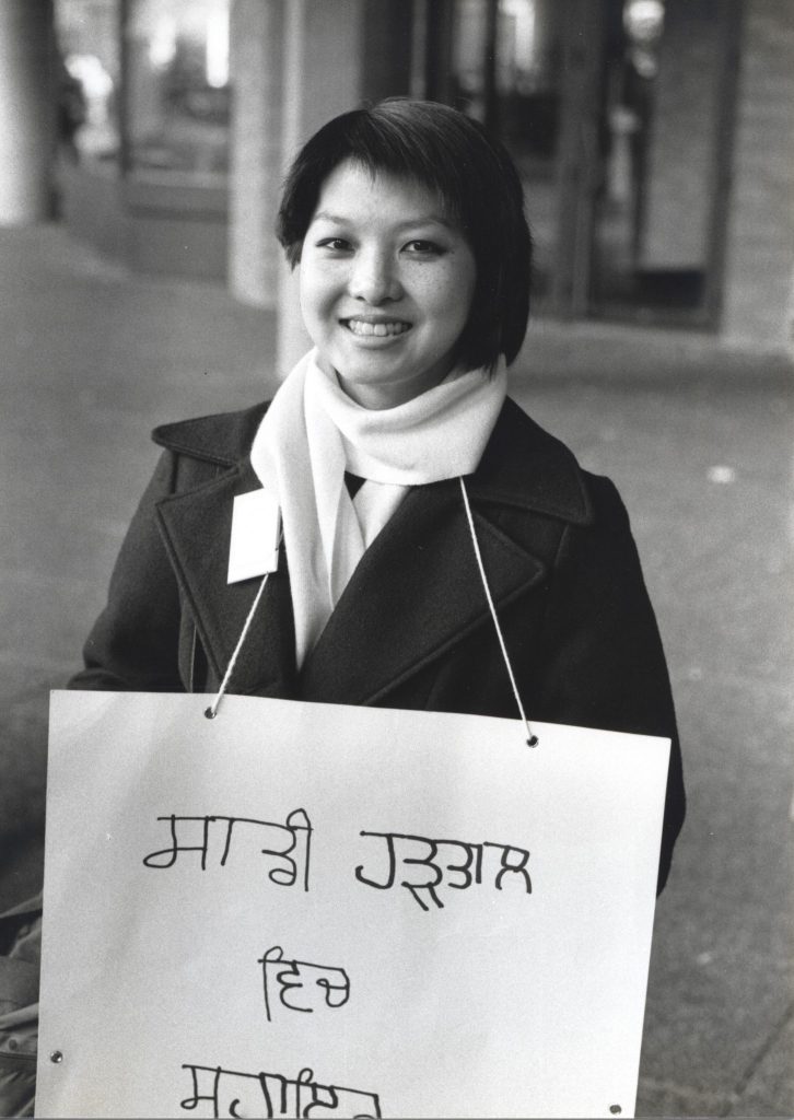 Shirley Lowe, a staff member of the Languages Department, holdes picket sign. Staff in this department provided services in over 40 languages, and many brought their own signs to the picket line.