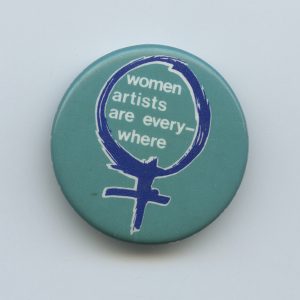 A button drawing attention to women artists.