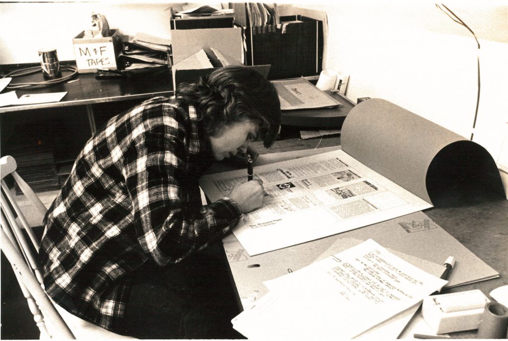 Cathy Carroll, now Billie Carroll, at the Women's Press office working on layout boards. Photo dates between 1972 and 1976. Photograph by Janice Acton.